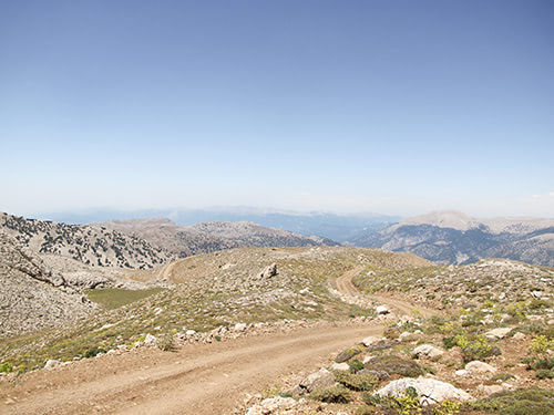 Blick von Schotterweg auf Gipfelebene ins Land
